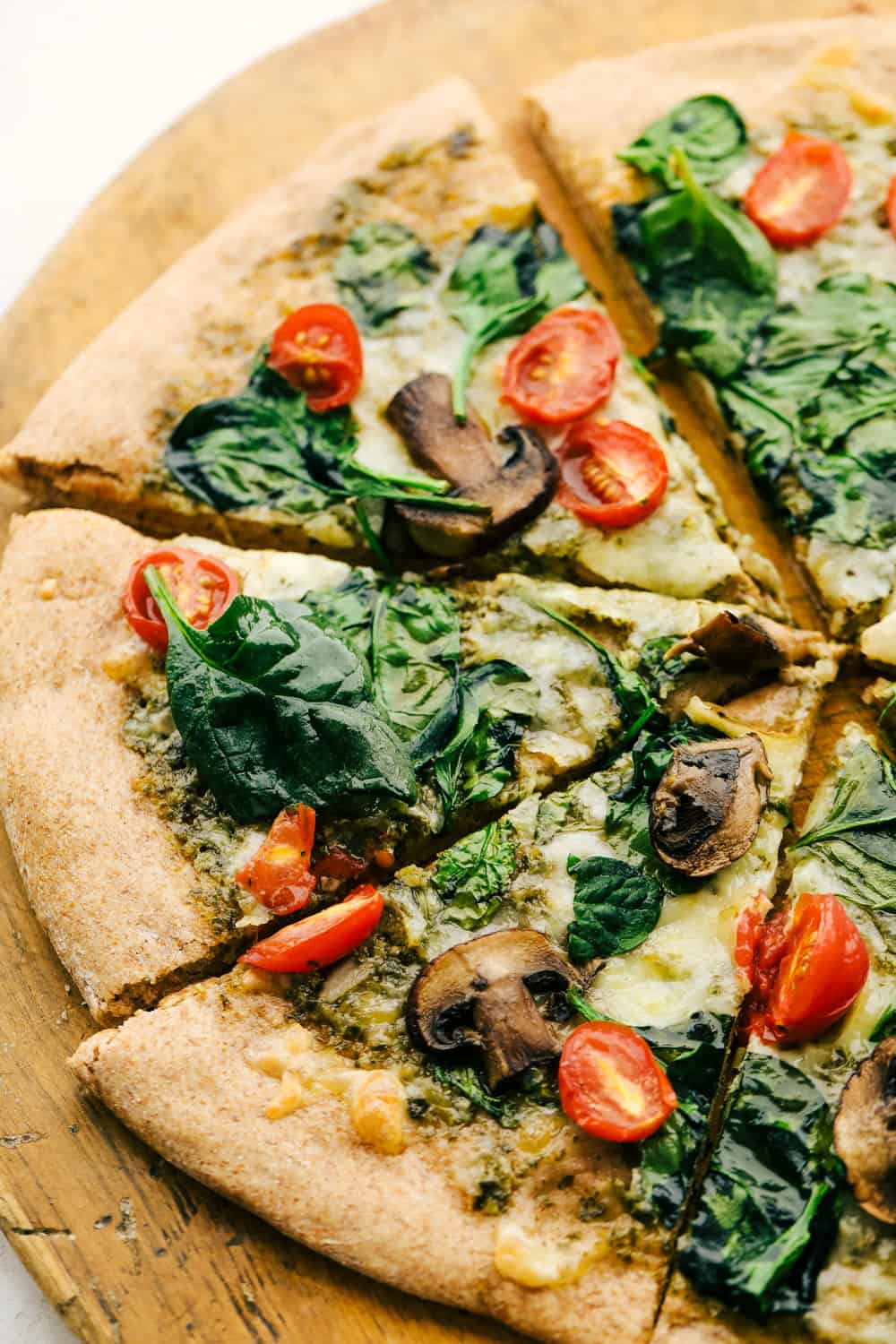 Whole wheat pizza dough topped with spinach, mushrooms and tomatoes.