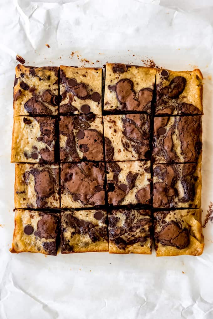 Swirled banana bread brownies cut into squares on parchment paper.
