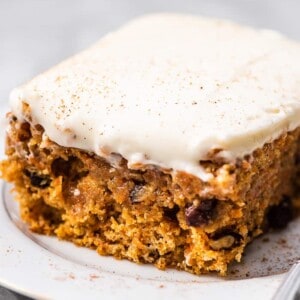 A carrot cake bar on a plate with a fork.