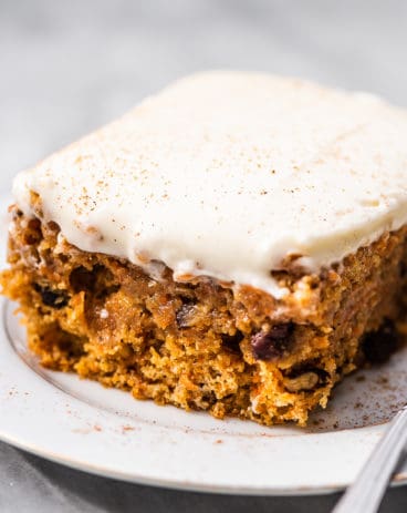 A carrot cake bar on a plate with a fork.