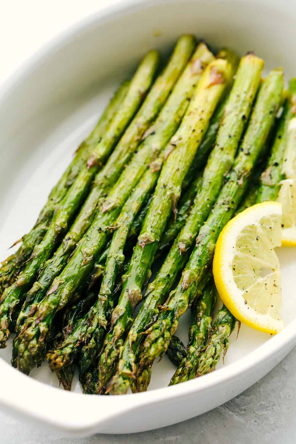 Air fryer roasted asparagus in a white dish. 