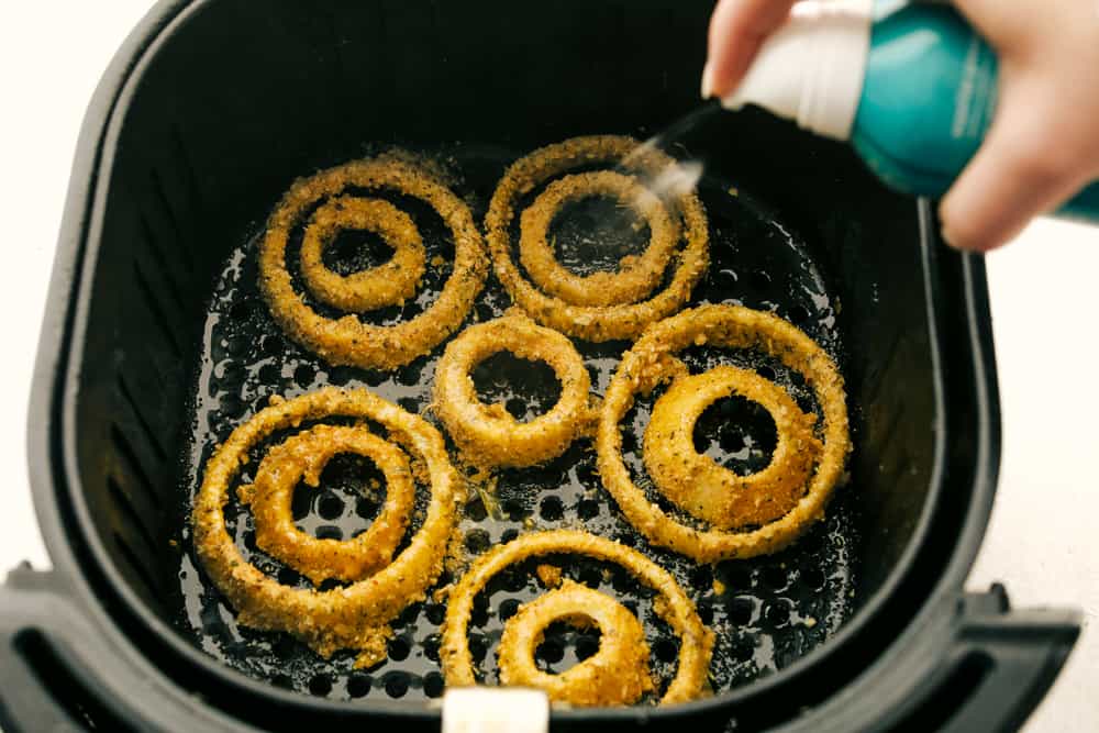 Onion rings in an air fryer basket. 