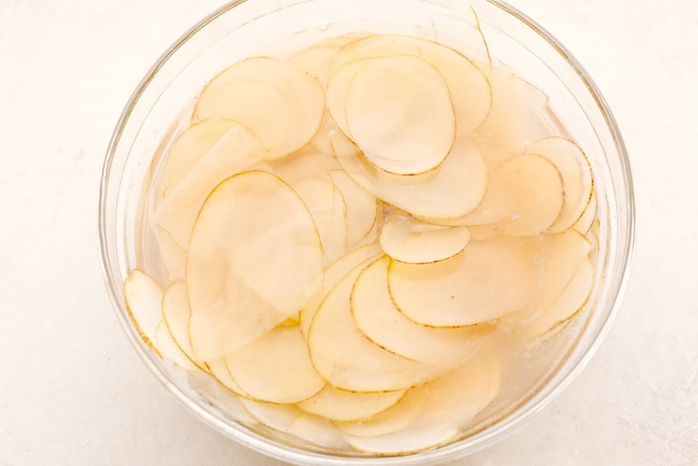 Soak potato slices in water. 