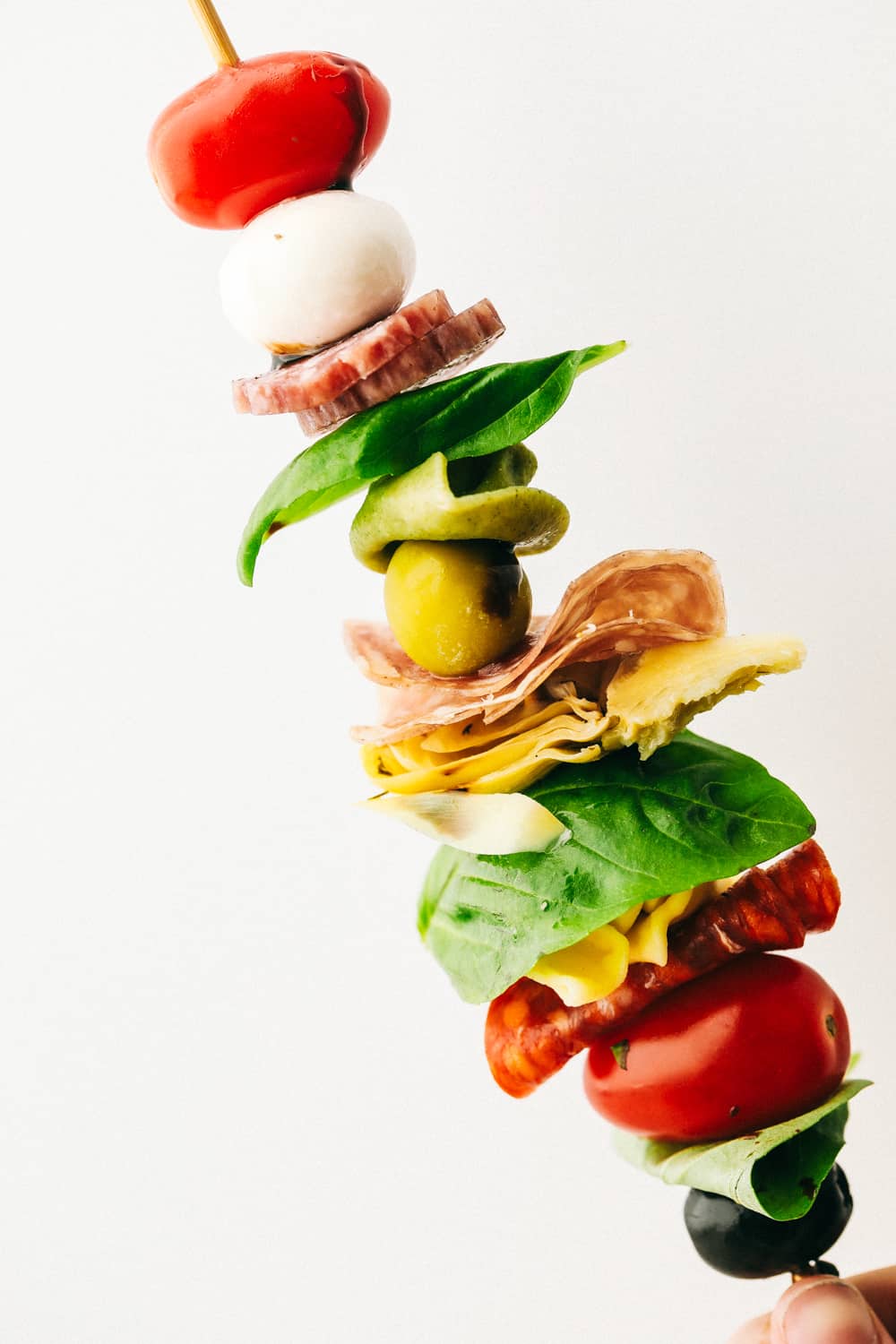 Up close look at an antipasto skewer layered with ingredients. 