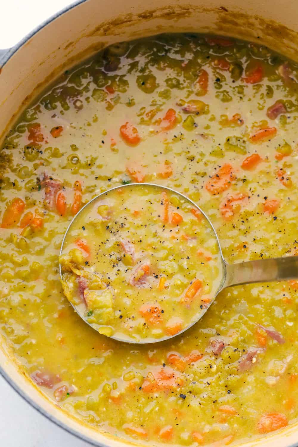 Ladling split pea soup out of stock pot. 