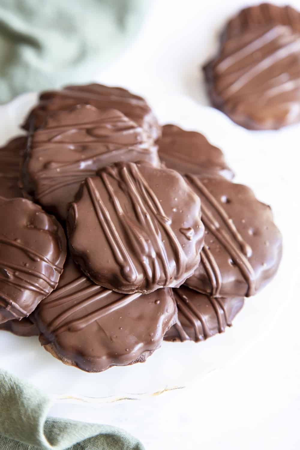 Crispy chocolatey homemade thin mint cookies staked on a plate. 