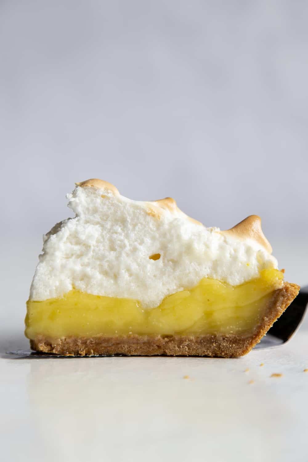A side view of the layers of lemon and meringue in the slice of pie.