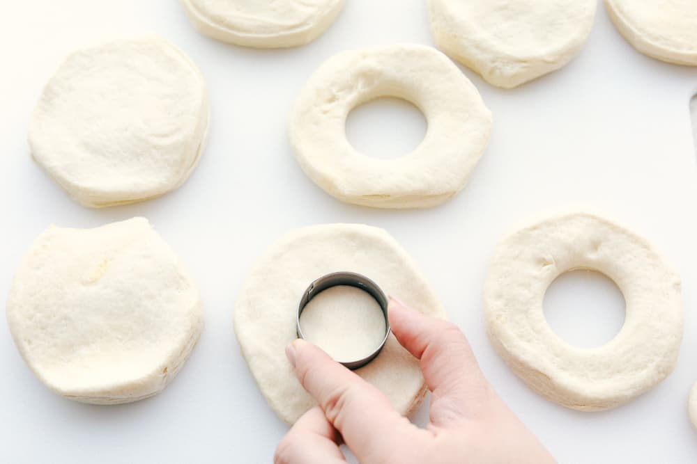 Cutting holes in biscuits for donuts. 