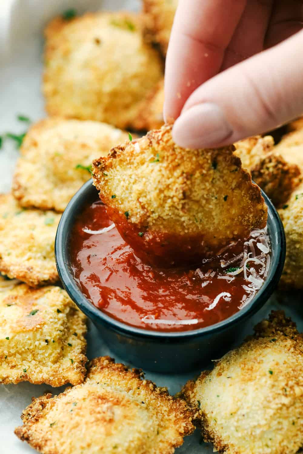 Dipping toasted ravioli in marinara. 