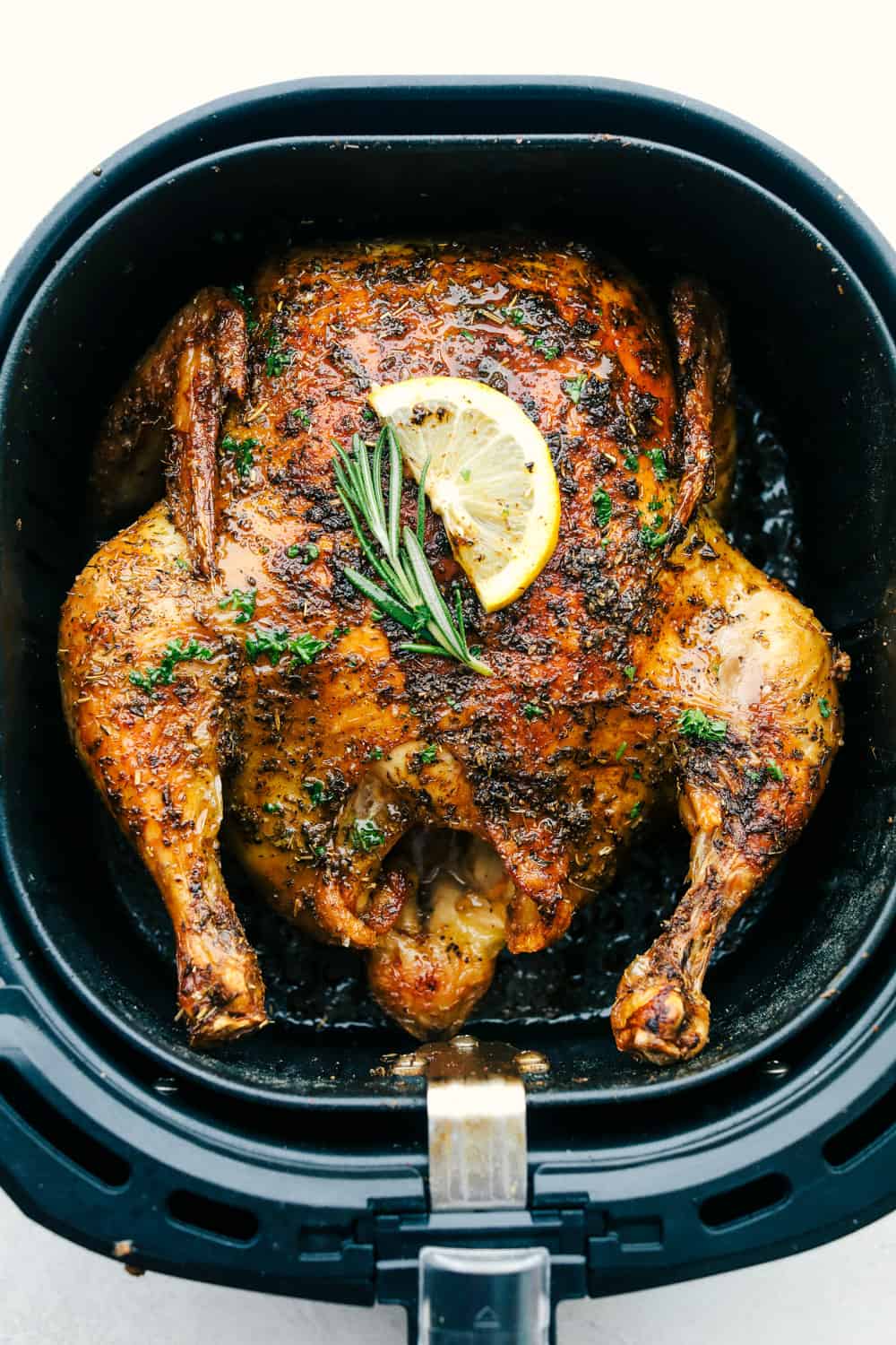 Top view of a whole chicken cooked in an air fryer.