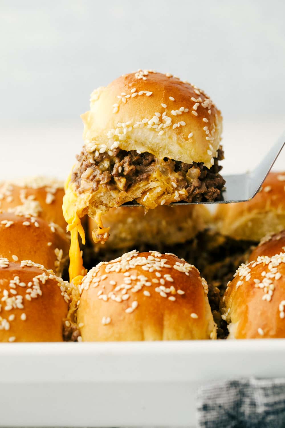 Lifting a cheeseburger slider out of a pan!