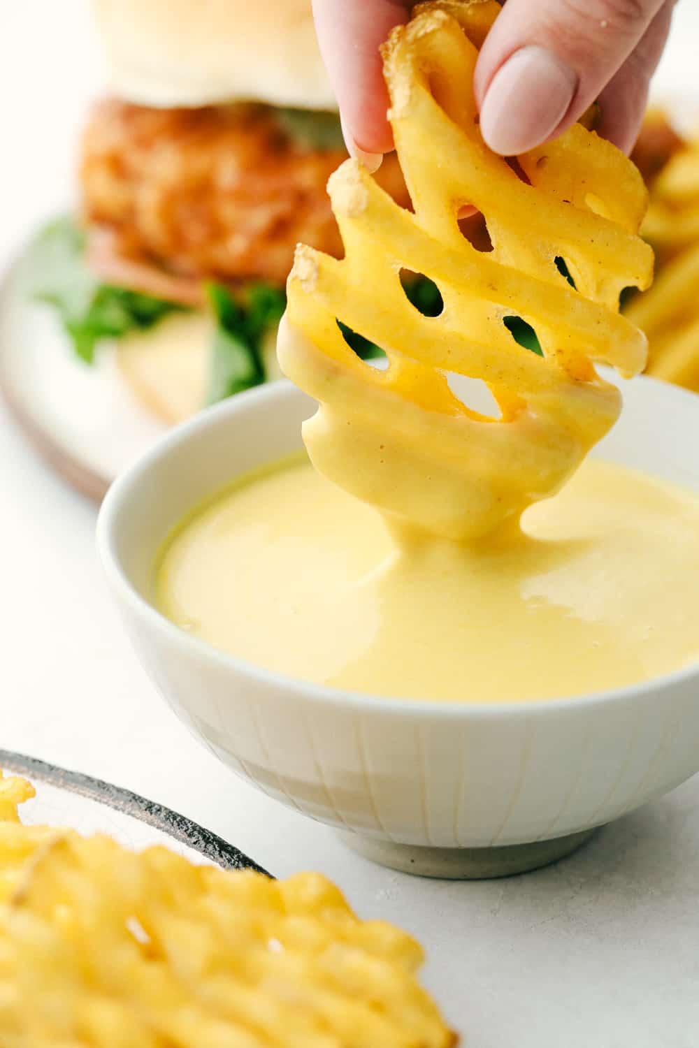 Dipping a waffle fry in Homemade Chick-Fil-A Sauce. 