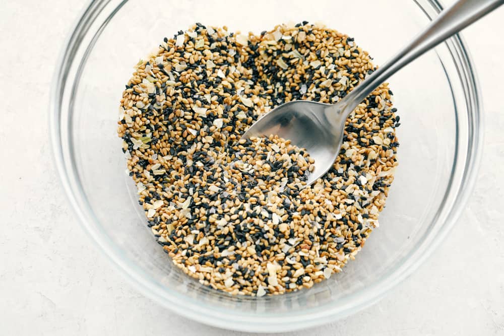 A bowl with the everything but the bagel seasoning and a spoon. 