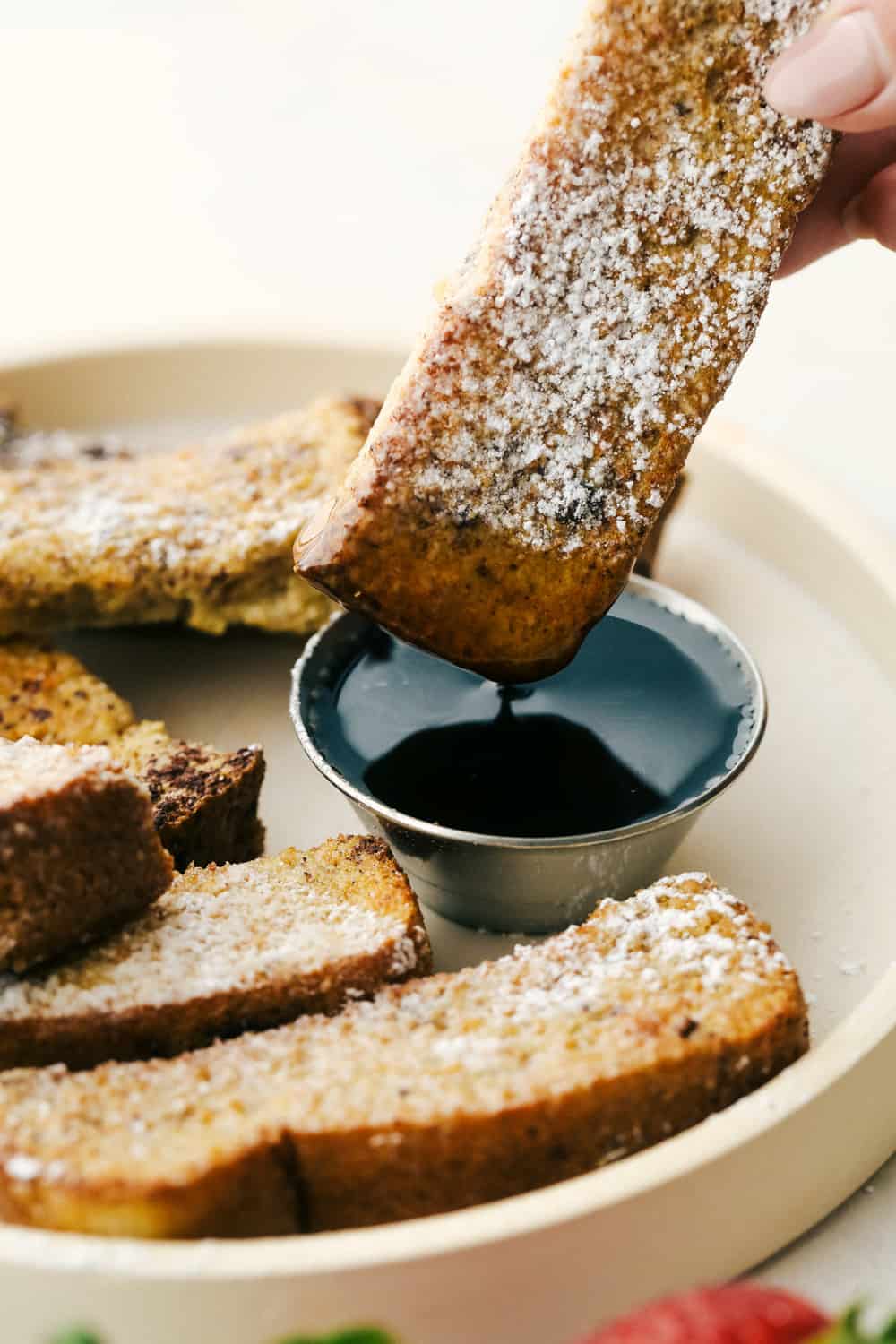 Dipping a french toast stick in maple syrup. 