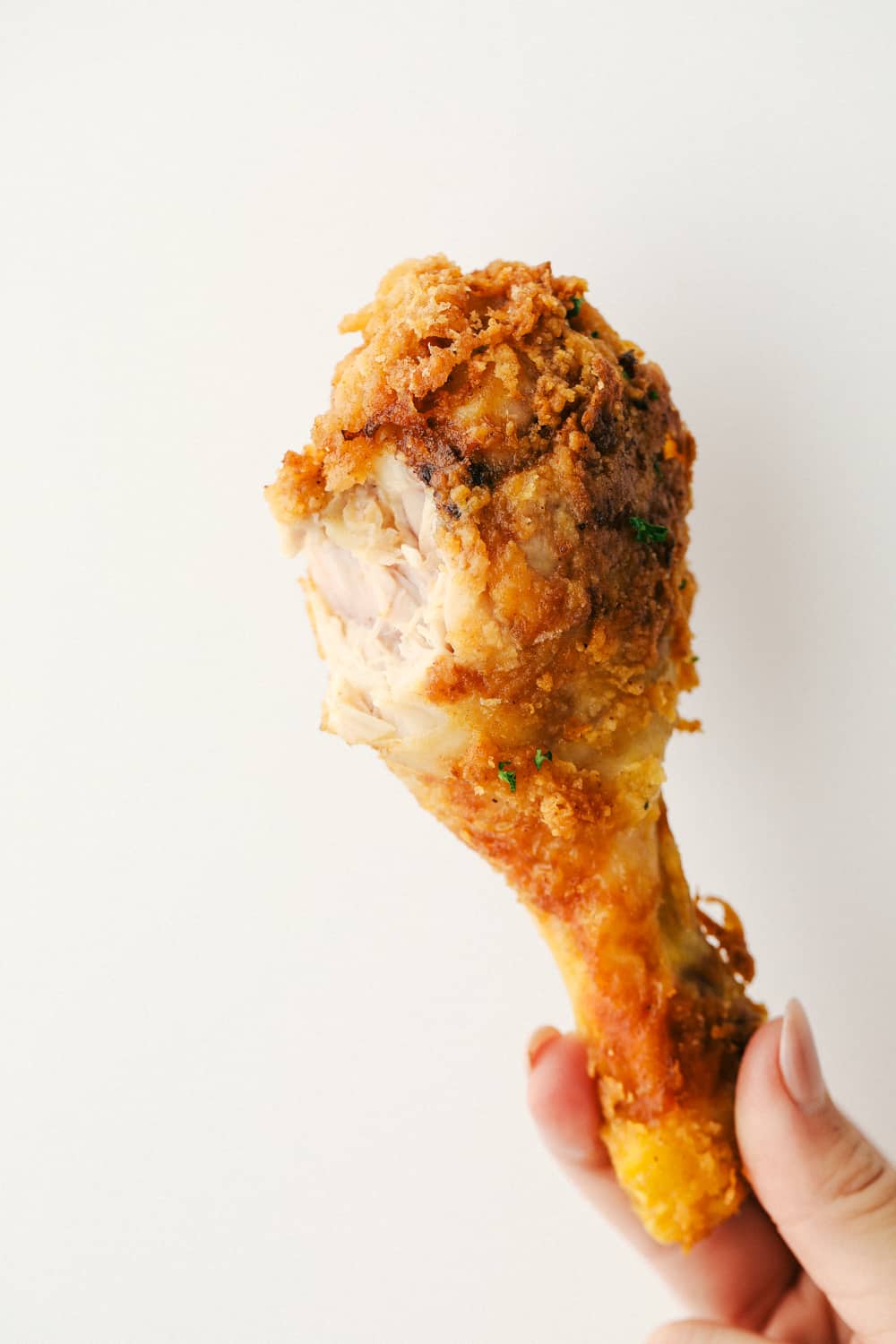 A chicken leg with a bite taken out of it. 