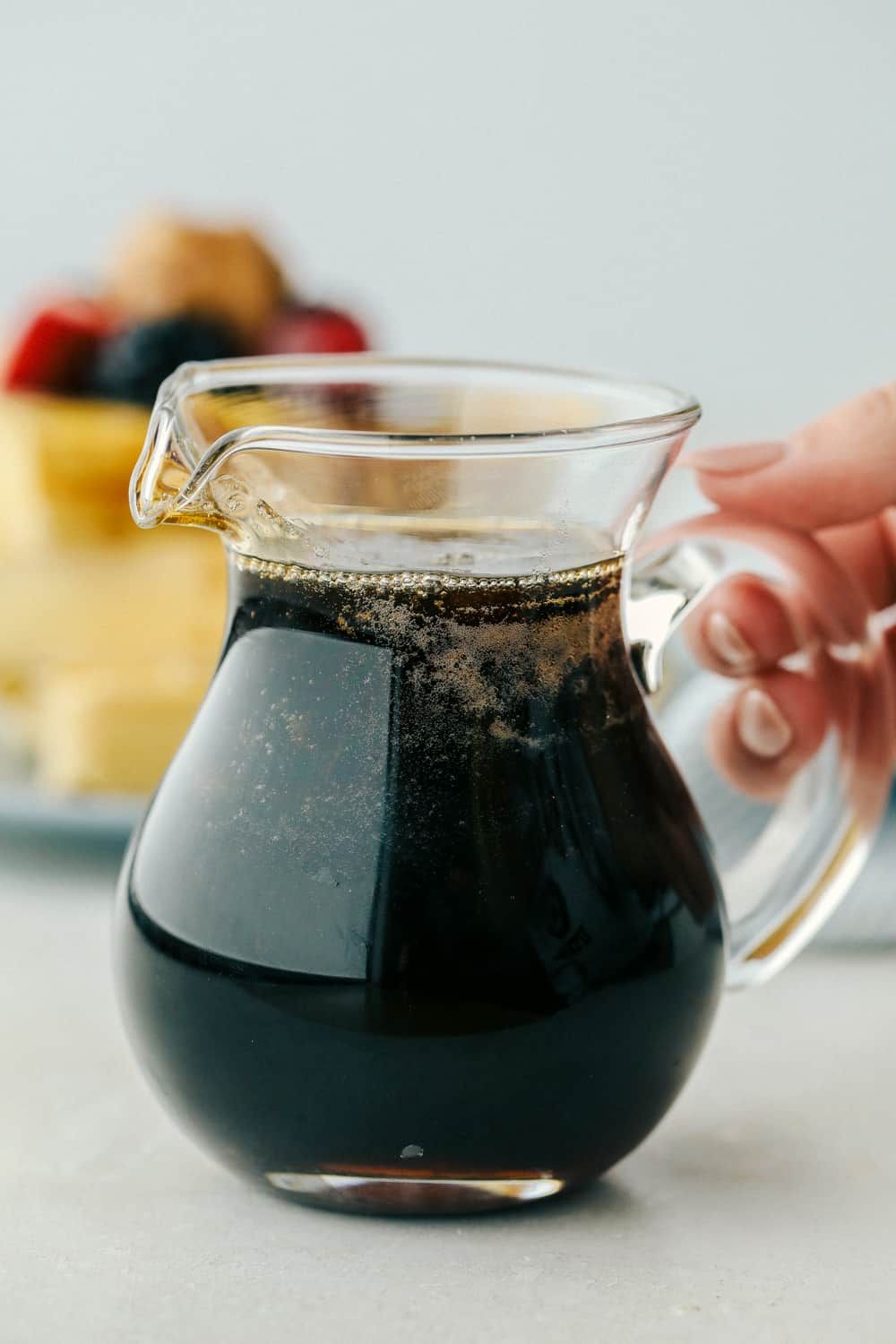 Homemade maple syrup in a pourable glass pitcher. 