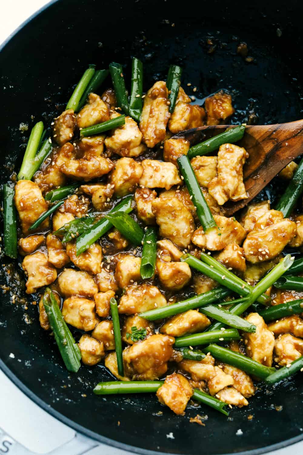 Chicken and green onions sauteed in a wok. 