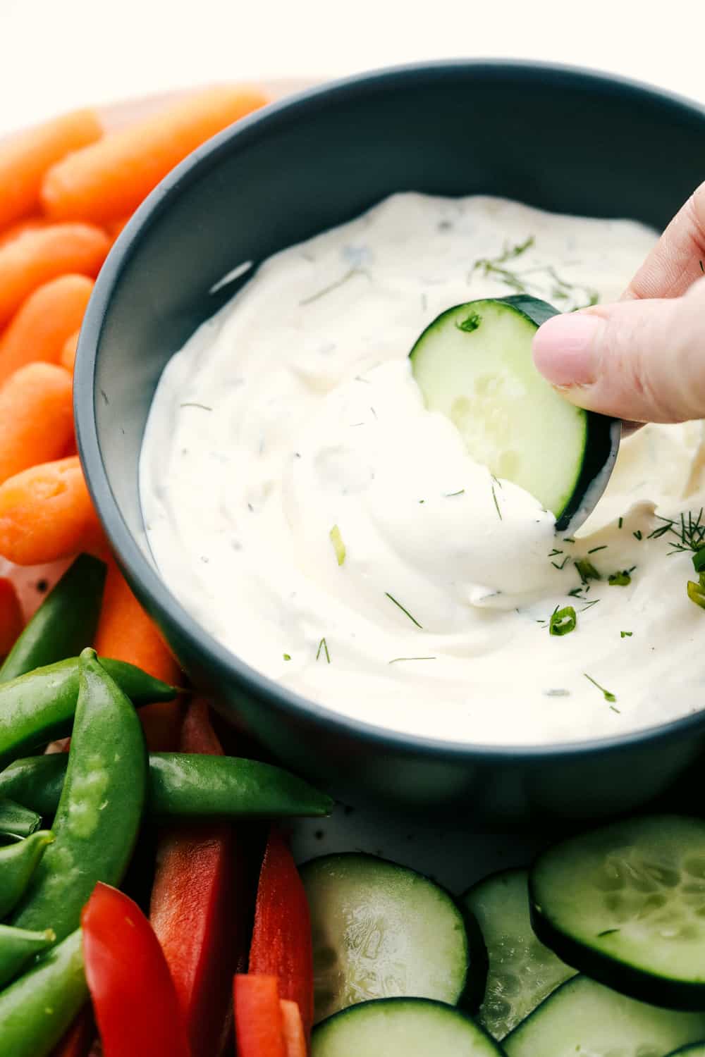 Dipping a cucumber in the dip. 