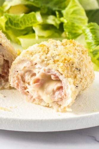 Closeup of the inside of chicken cordon blue with cheese oozing out.