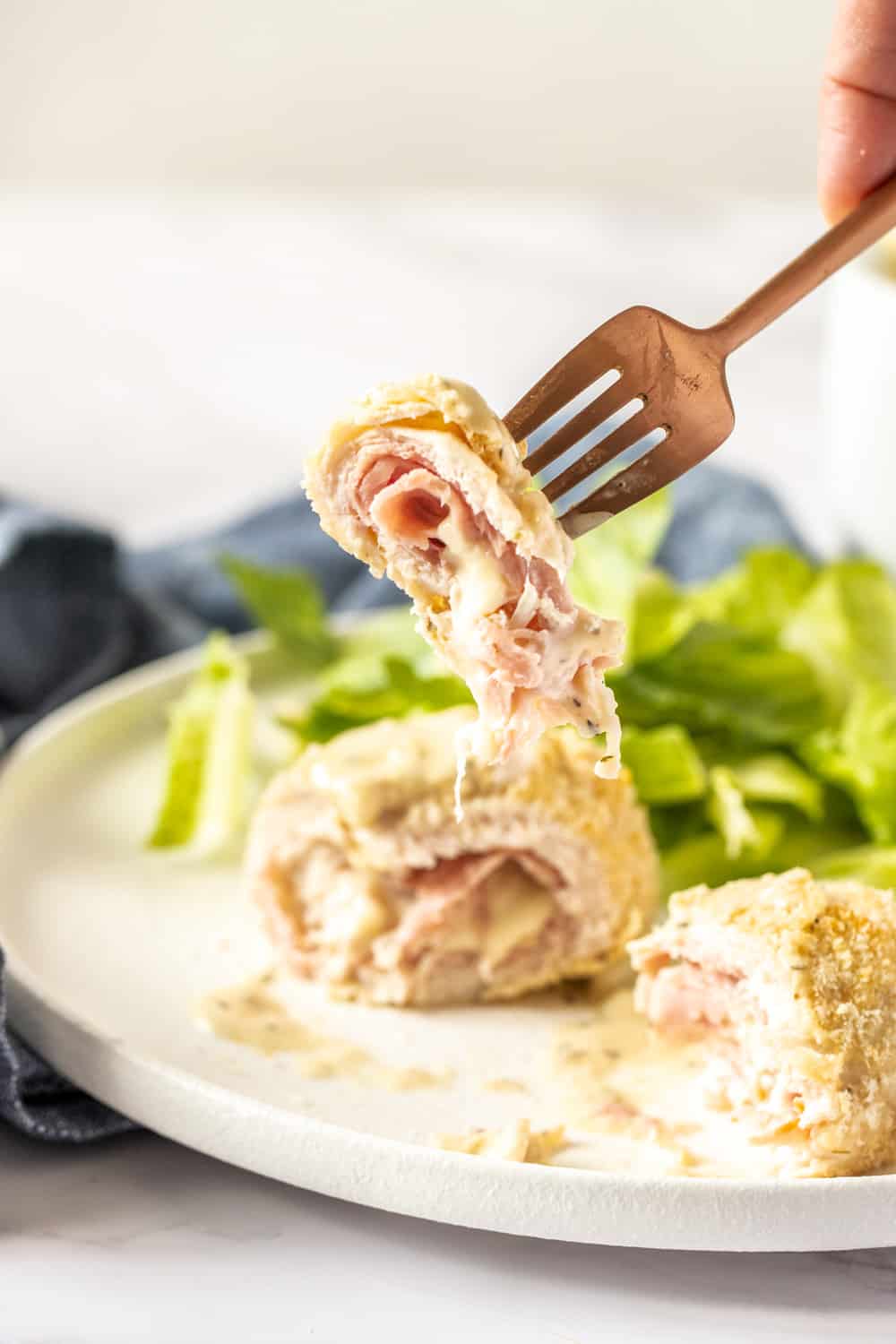 Chicken cordon bleu on a fork showing the inside layers.