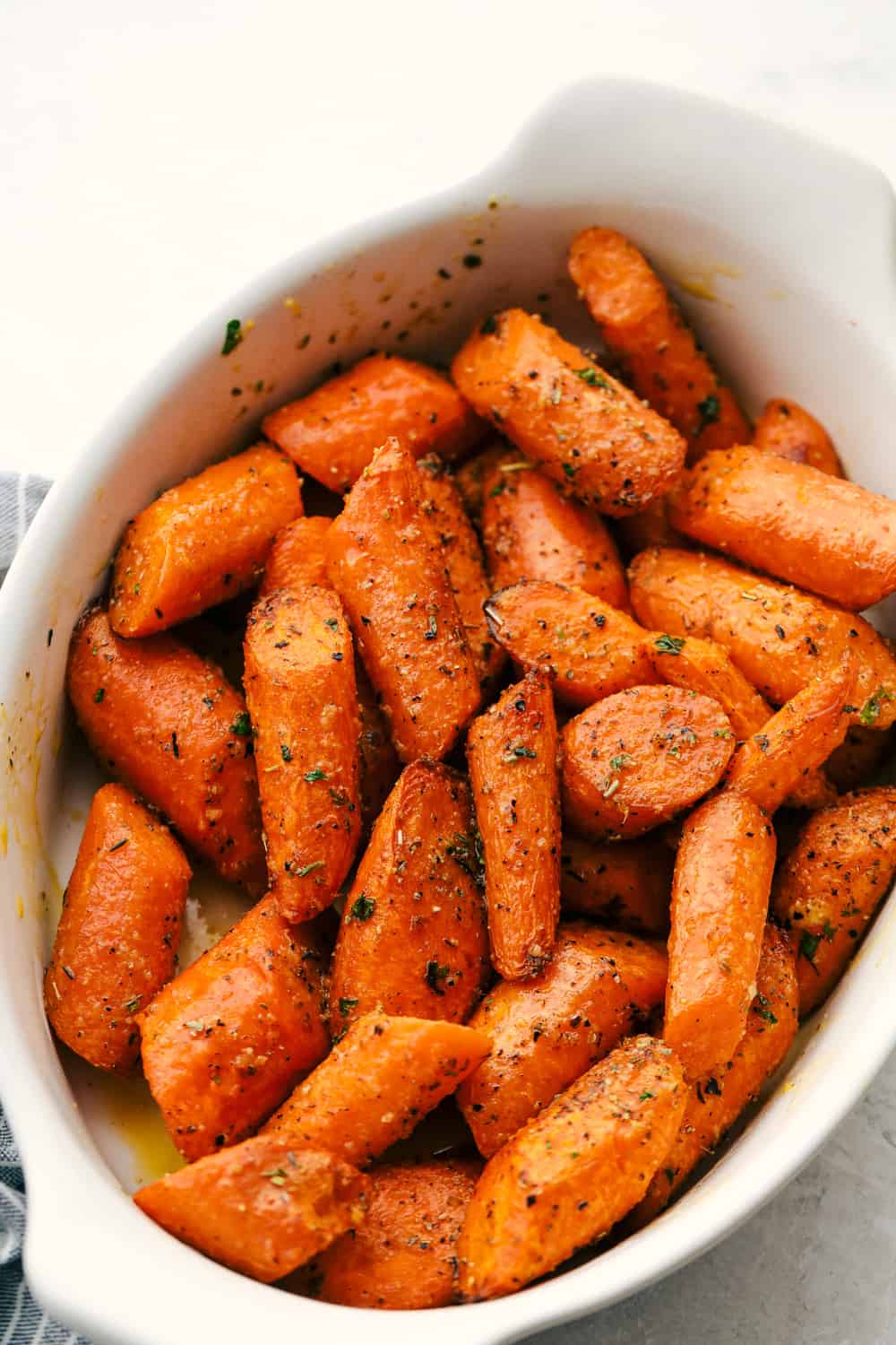 Cooked carrots in a white dish.