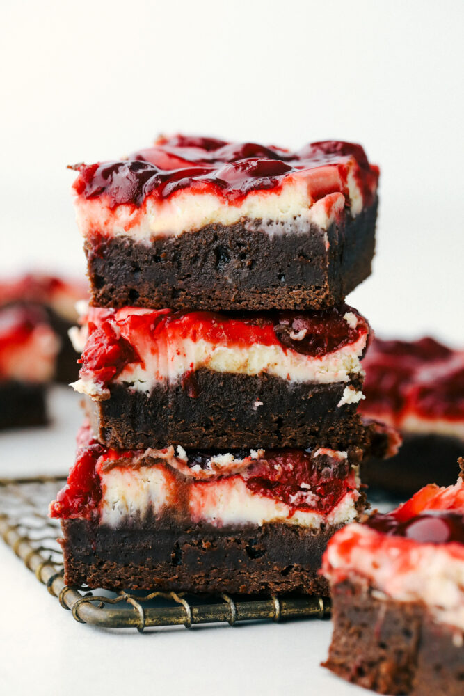 Cherry Cheesecake brownies stacked on top of each other. 
