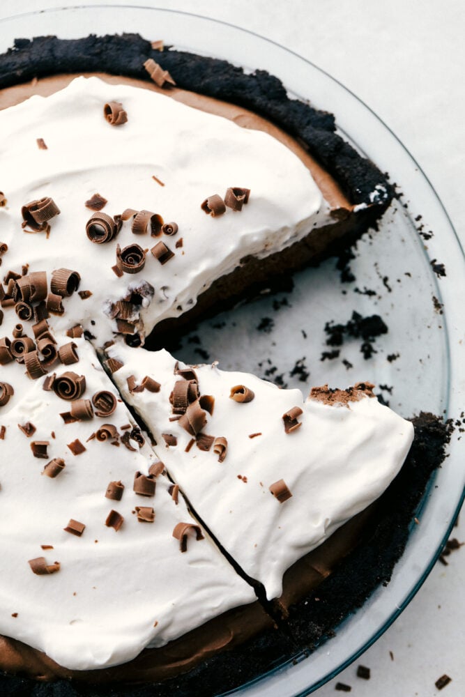 Chocolate pie with a slice missing and chocolate curls on top. 