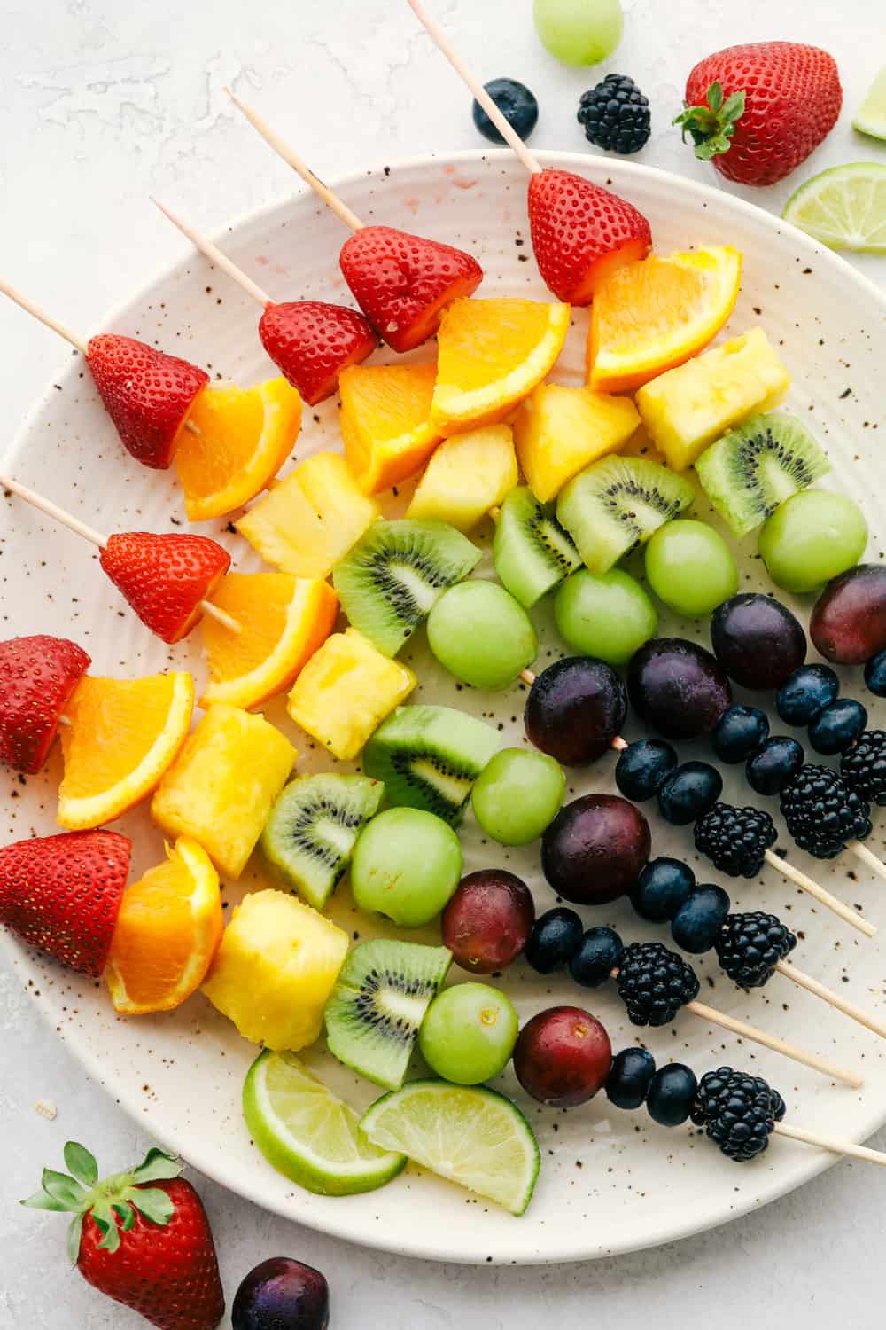 Rainbow fruit skewers on a plate. 