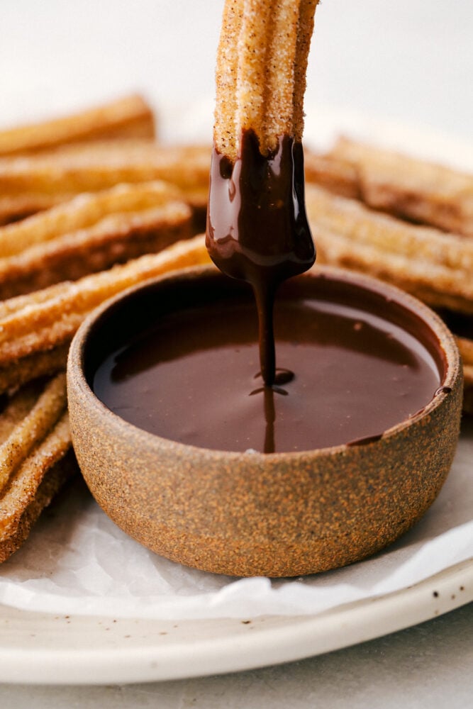 Dipping a churro in chocolate sauce. 