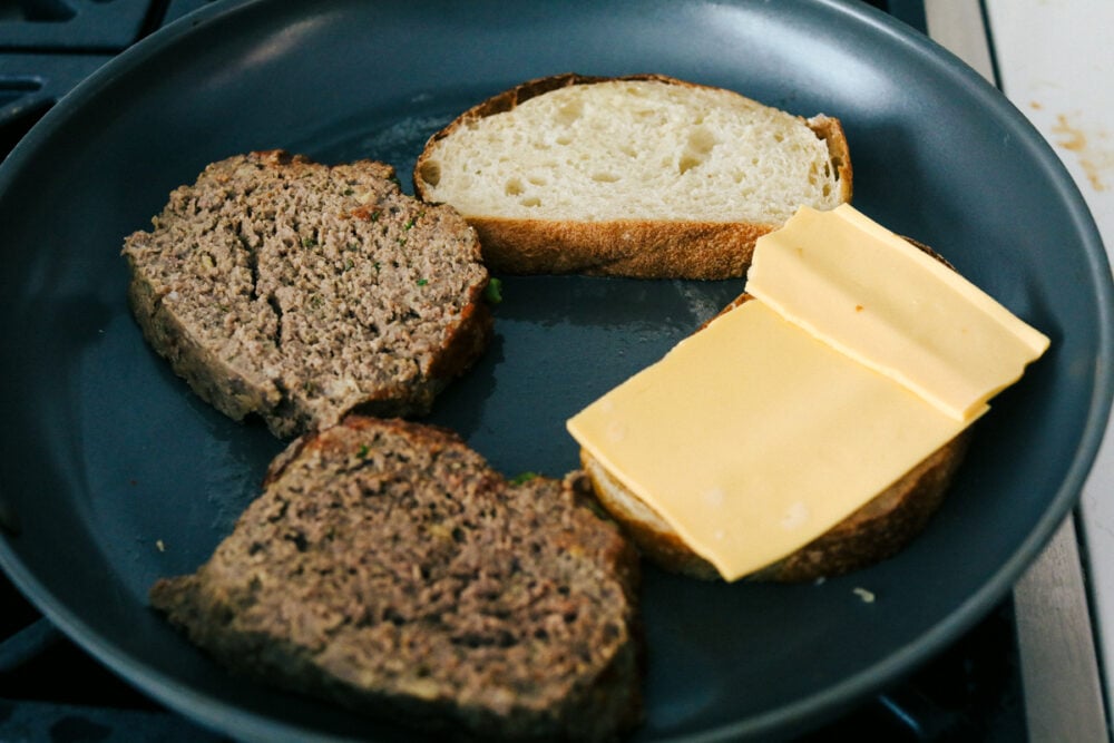 Grilling the meatloaf, and bread topped with cheese. 