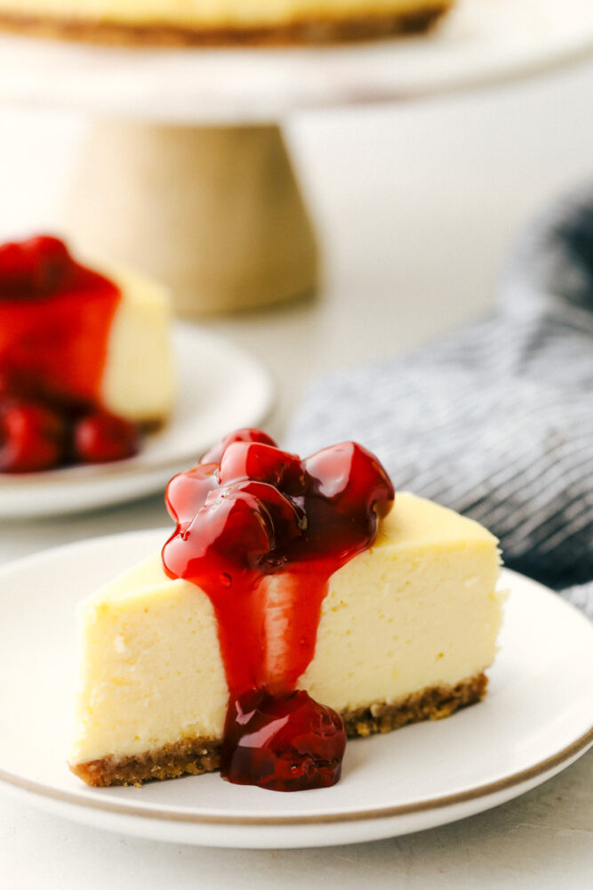 Cheesecake slice topped with cherry pie filling. 
