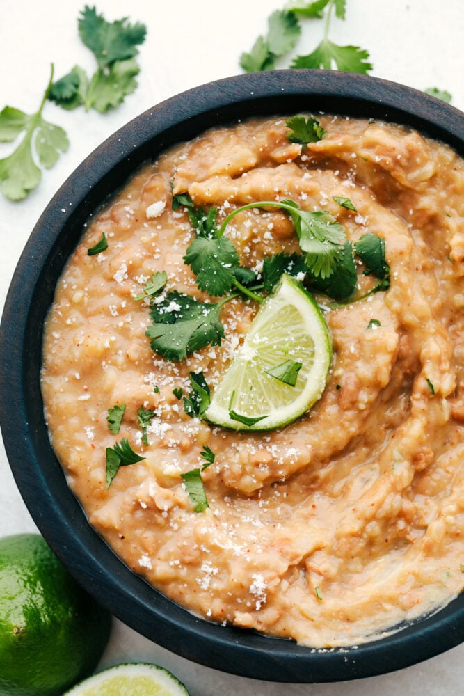 A bowl of refried beans in a black bowl. 