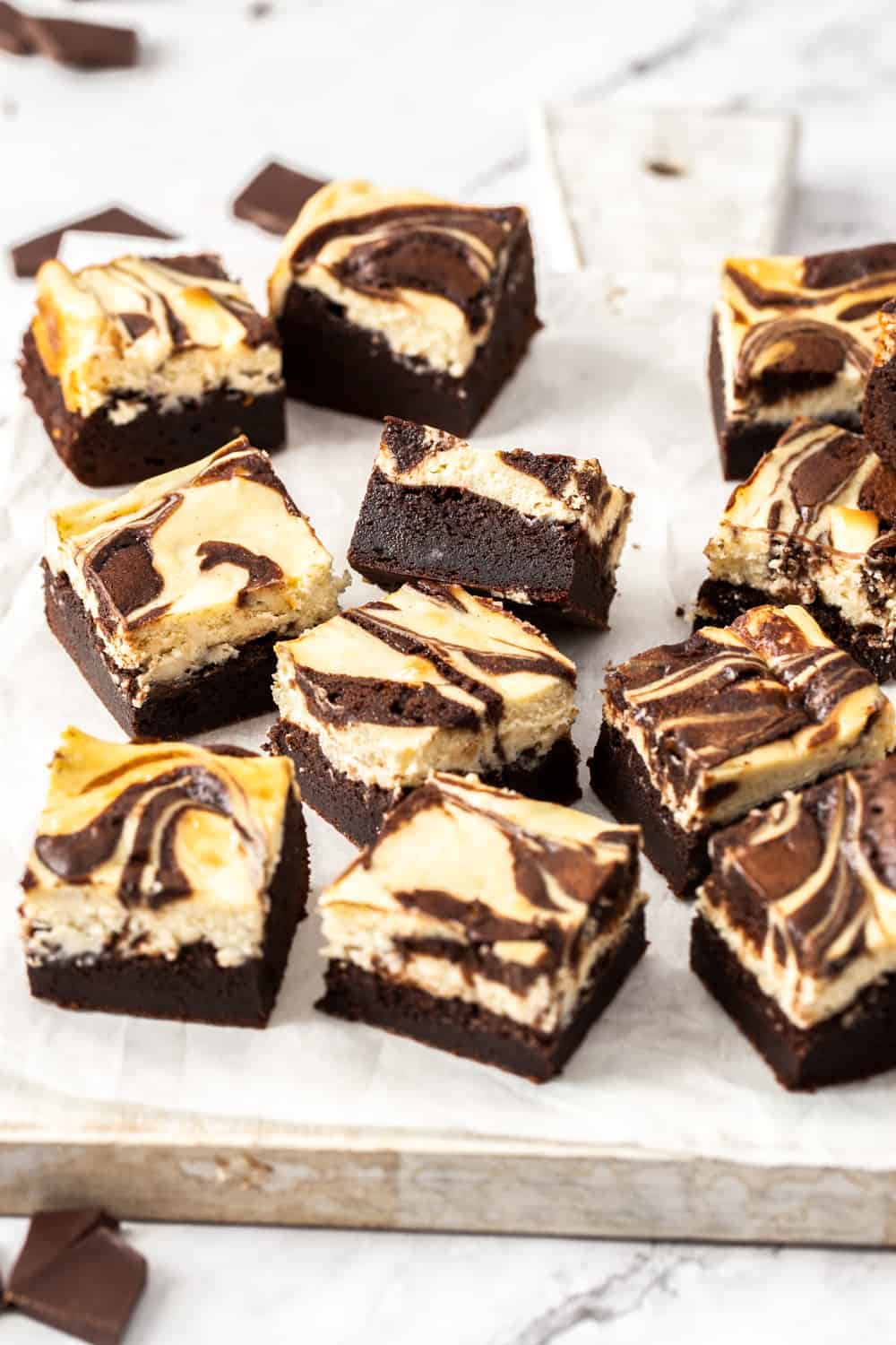 A batch of brownies on a white wooden board.