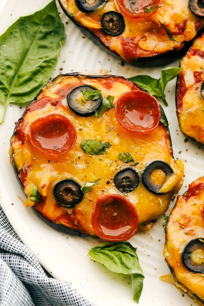 Eggplant pizzas with garnish on plate.