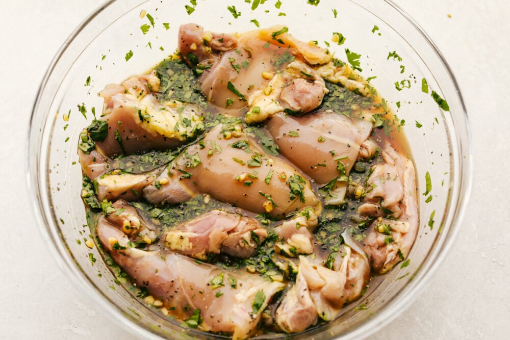 chicken marinating in the bowl of seasonings. 