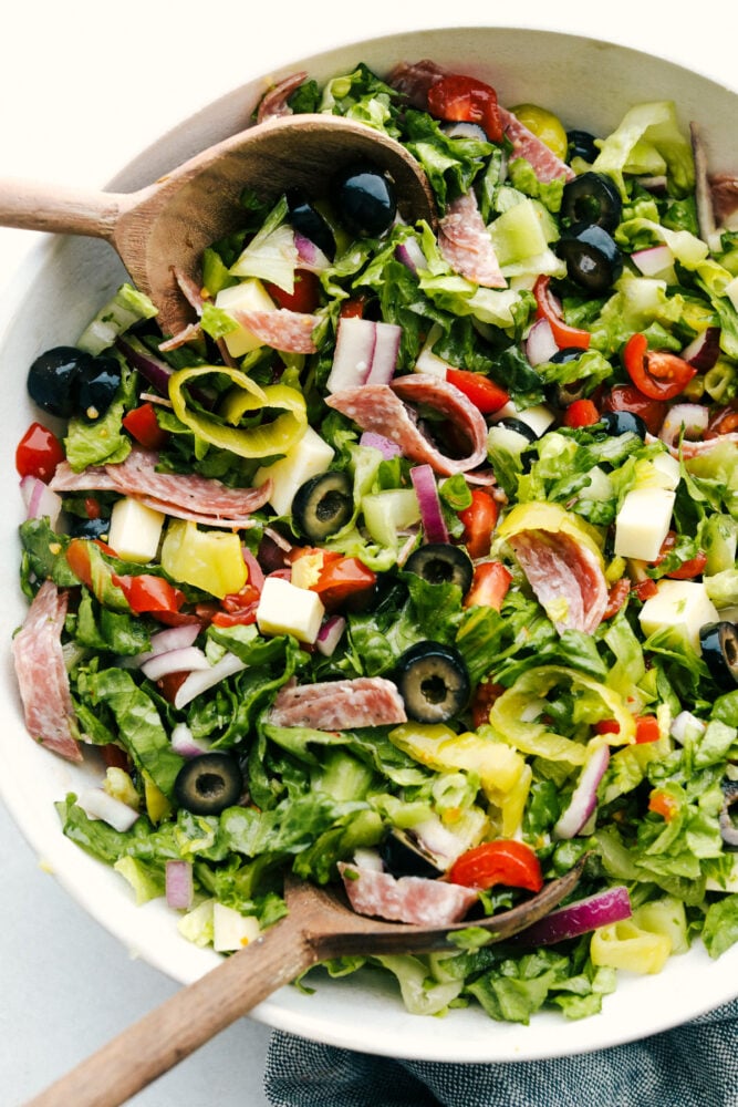 A bowl of Italian chopped salad with serving spoons