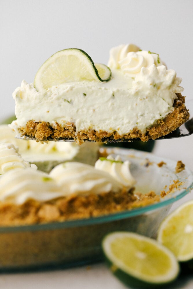 A slice of key lime pie being lifted from the tin.  