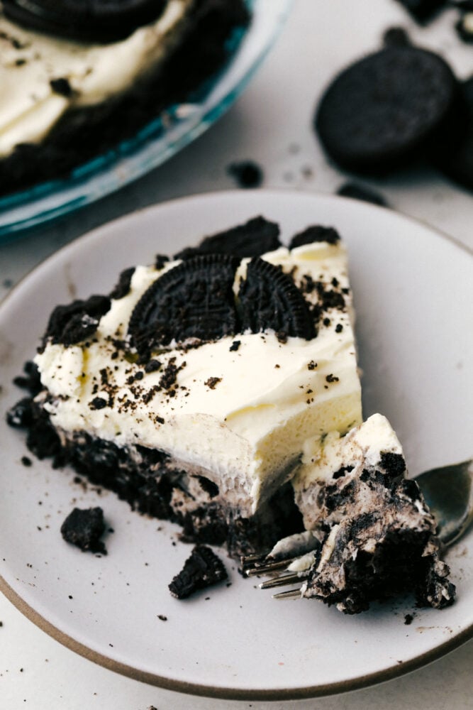 A slice of Oreo pie on a plate, decorated with Oreos. 