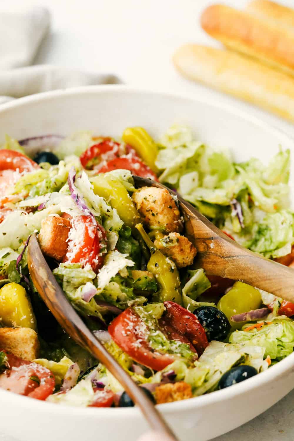Copycat Olive Garden Salad is one of my all-time favorite restaurant salads, and now you can make it right at home. Itโs bright, zesty, and packed with that fresh, irresistible flavor everyone loves. Someone tossing the salad with the dressing.