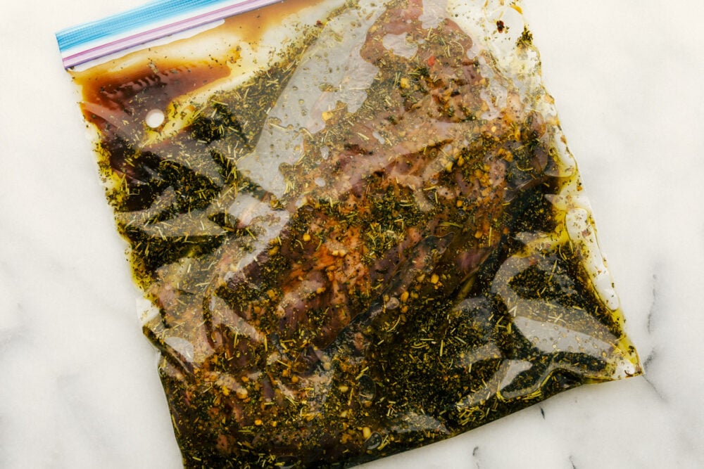 Rock steak and marinade in a sealed plastic bag. 