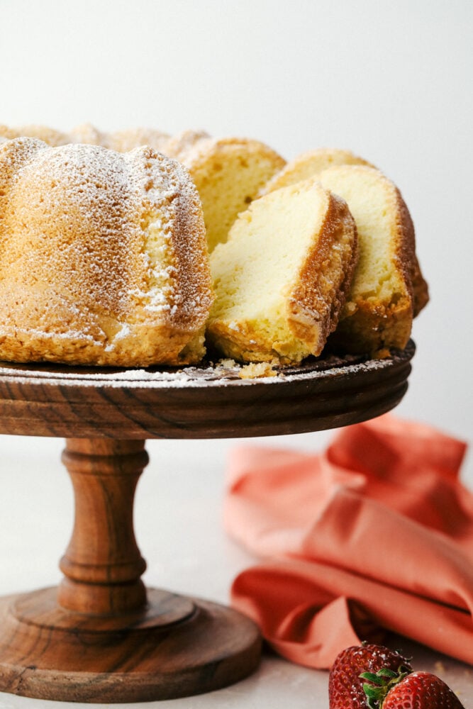 Sour cream pound cake sliced sitting on a pedestal stand. 