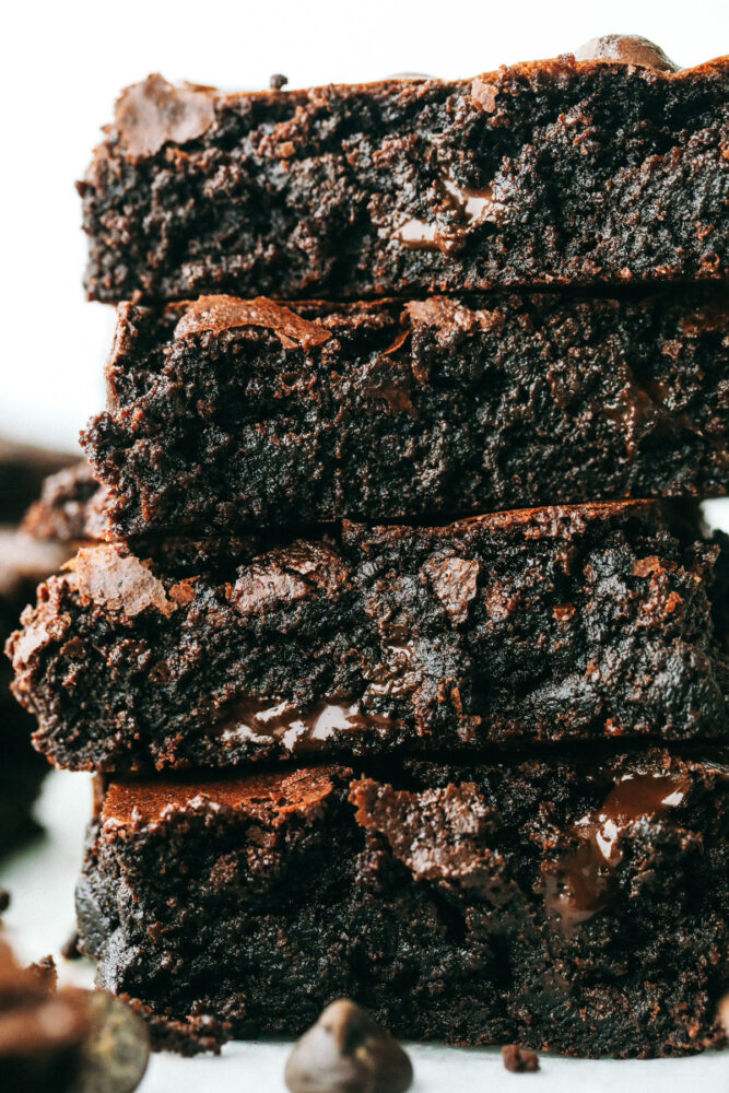 Close up of fudgy chocolate brownies cut into squares and stacked. 