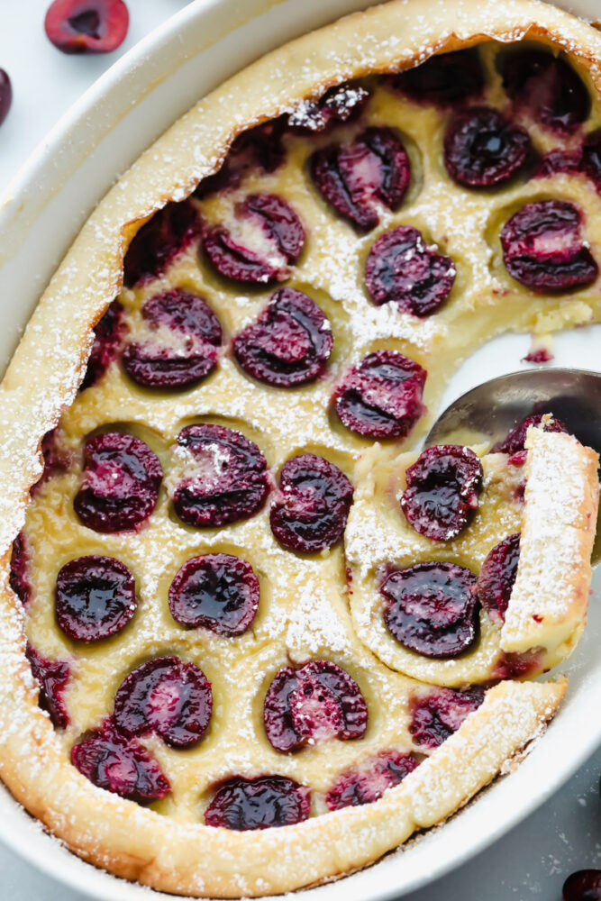 Scooping out the cherry clafoutis from the serving dish. 