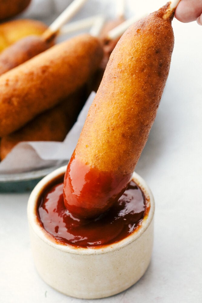 Dunking a corndog in ketchup. 