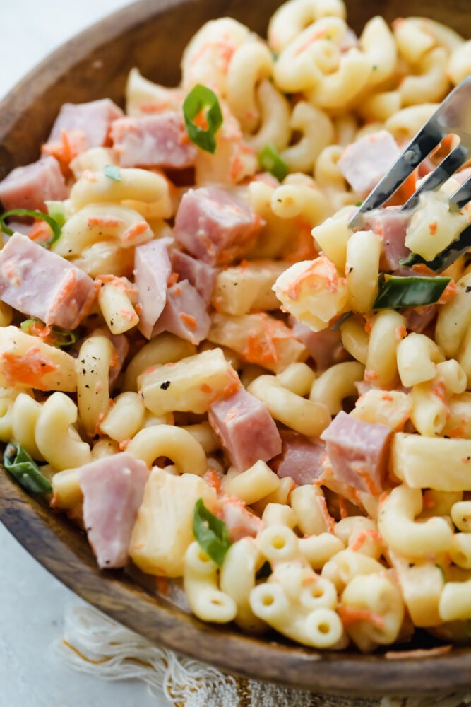 Scooping a bite of the macaroni salad with a fork. 