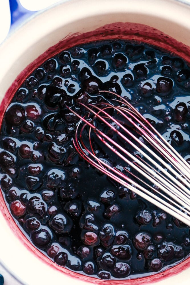 Blueberries being whisked in a bowl