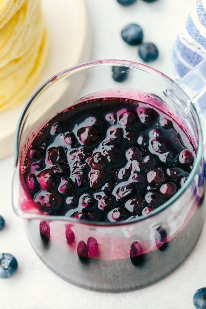 Blueberry syrup in a measuring cup.