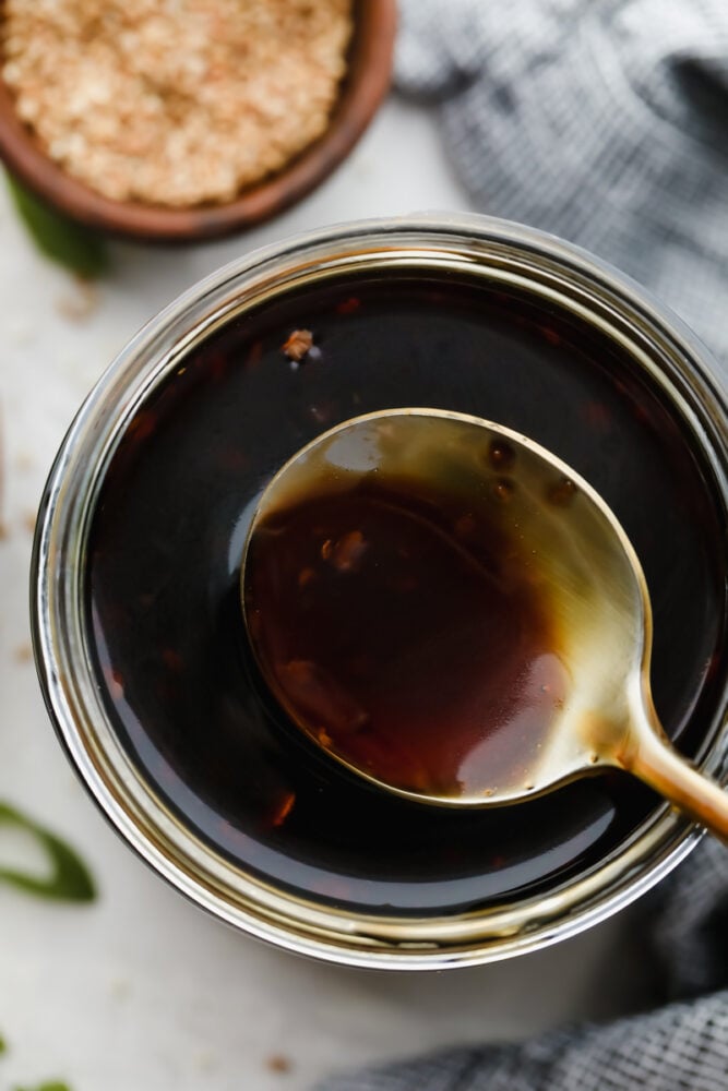 Scooping out a spoonful of teriyaki sauce from the jar. 