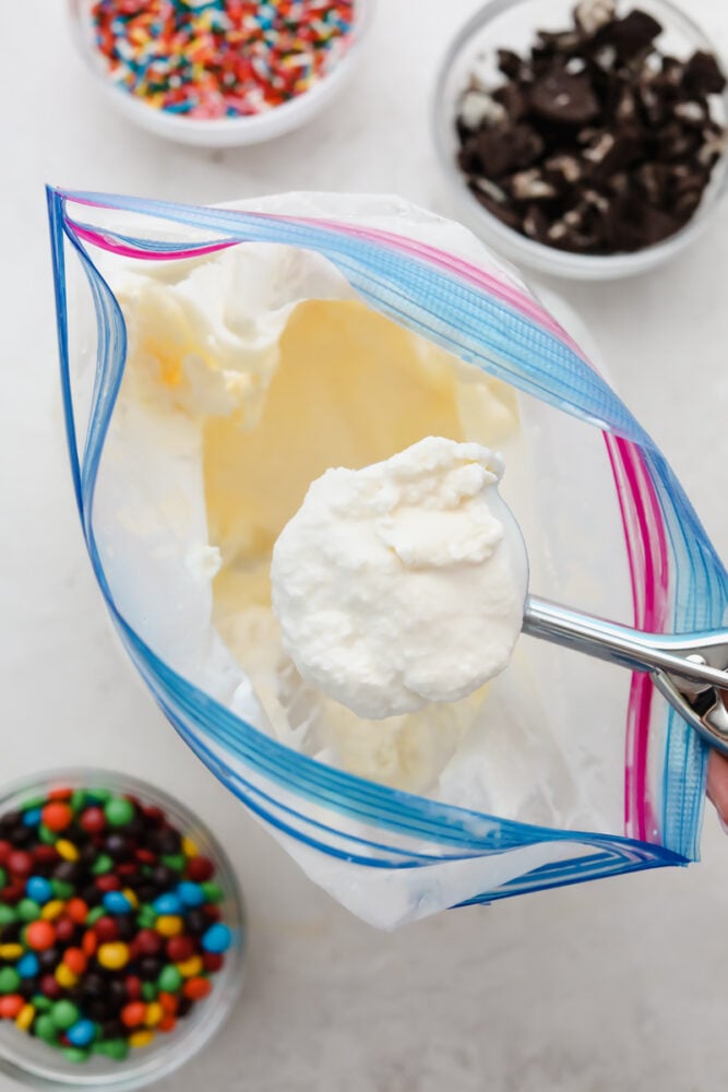 Homemade ice cream in a bag being scooped out with a spoon. 