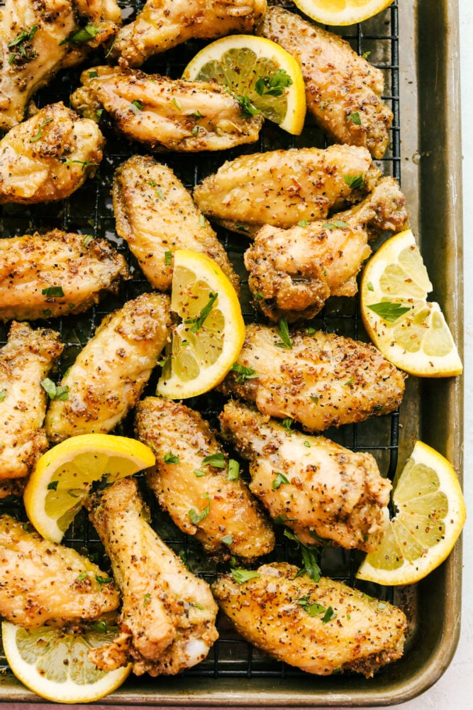 Lemon Pepper Wings on a baking rack with lemon garnish